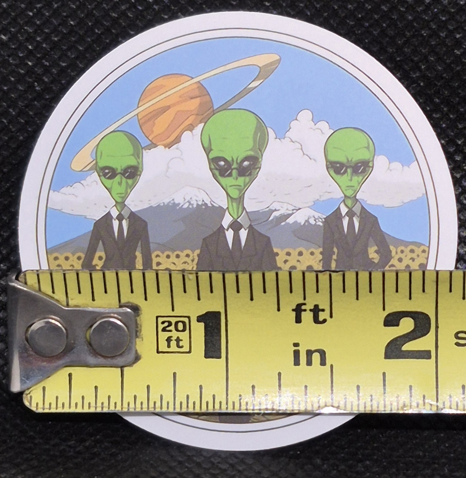 Men In Black Alien UFO UAP Round Decal Sticker. Approximately 2"