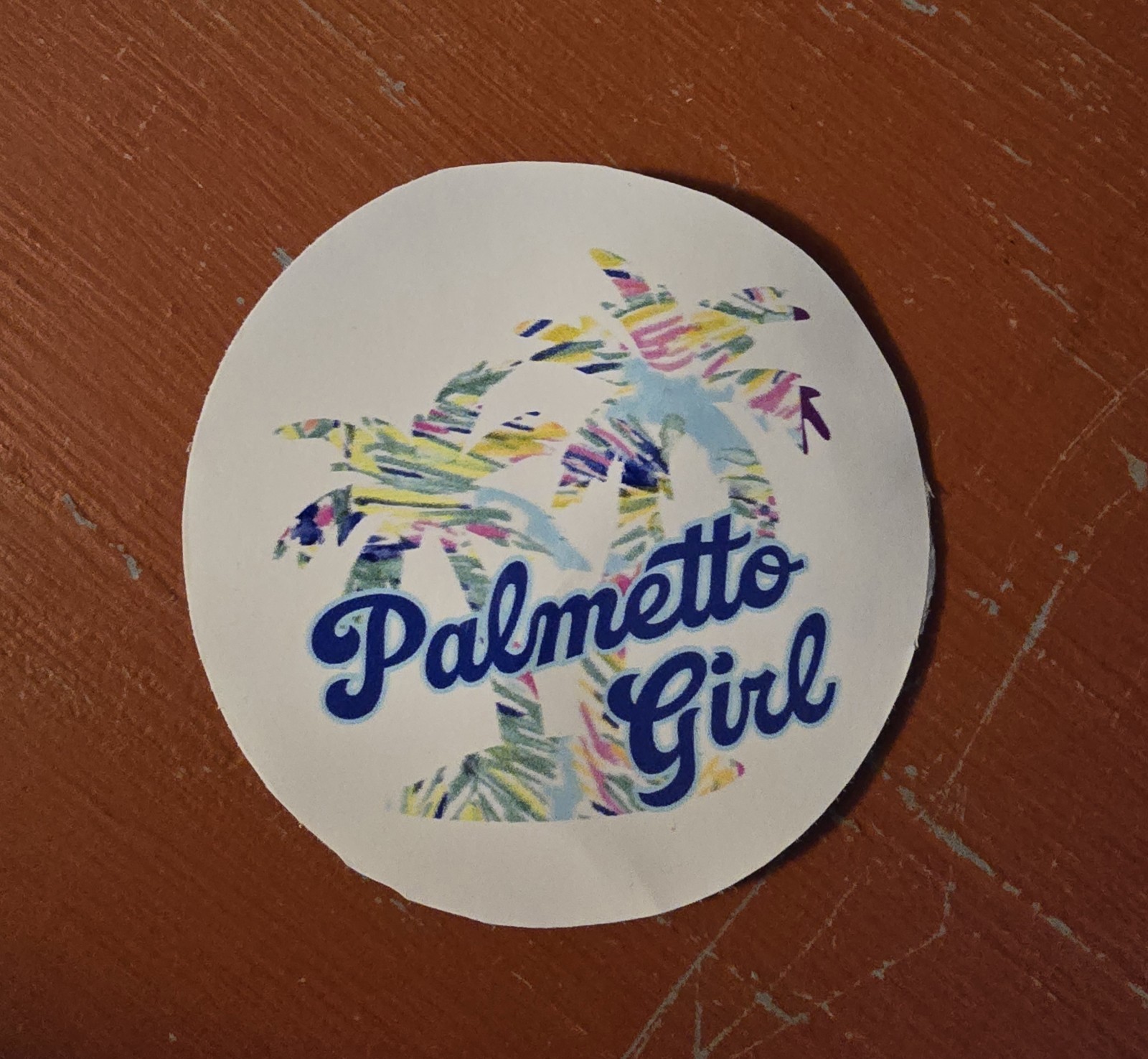 'Palmetto Girl' text and a colorful palm trees background design. 3in Sticker