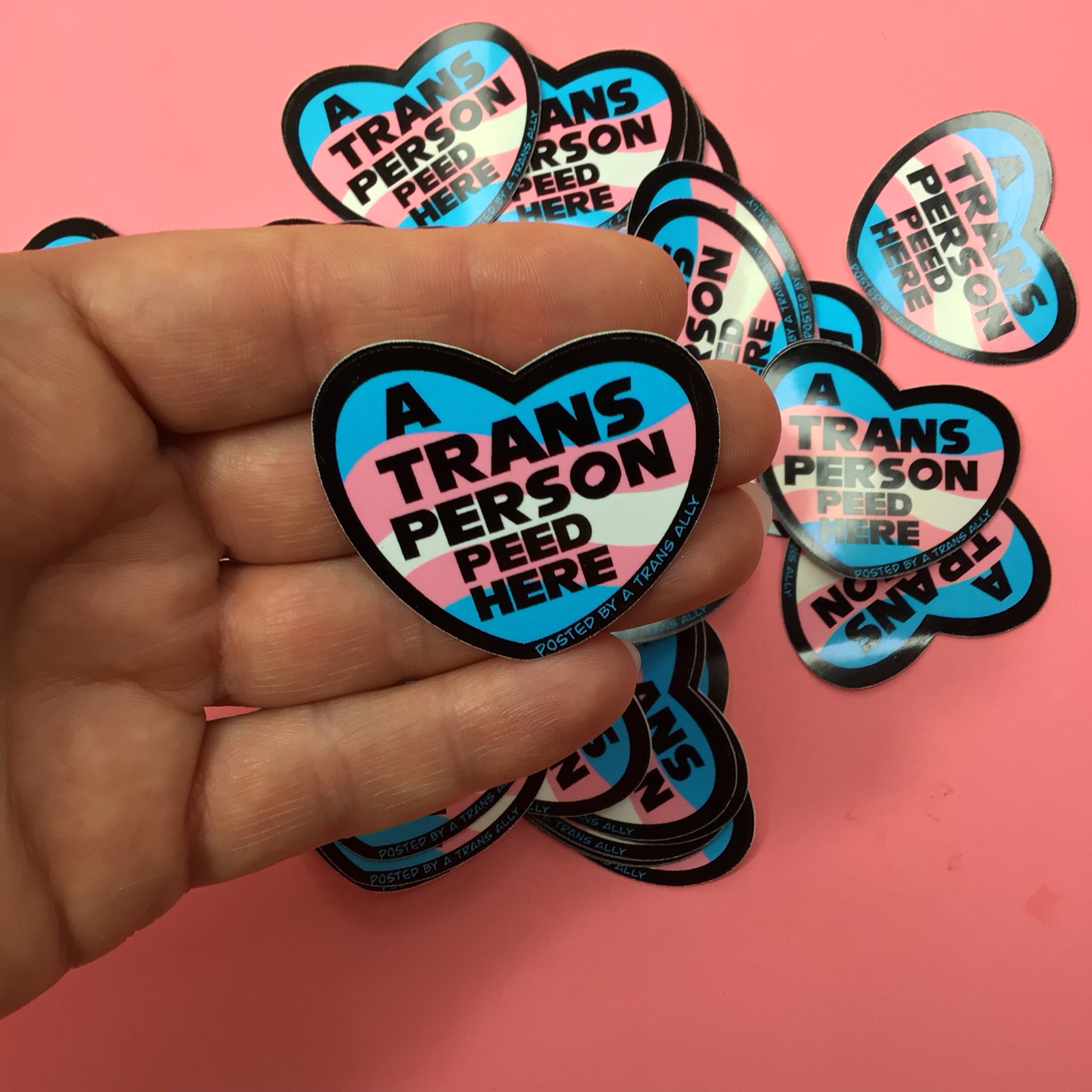 A trans person peed here. Posted by a Trans ally – Vinyl waterproof sticker.