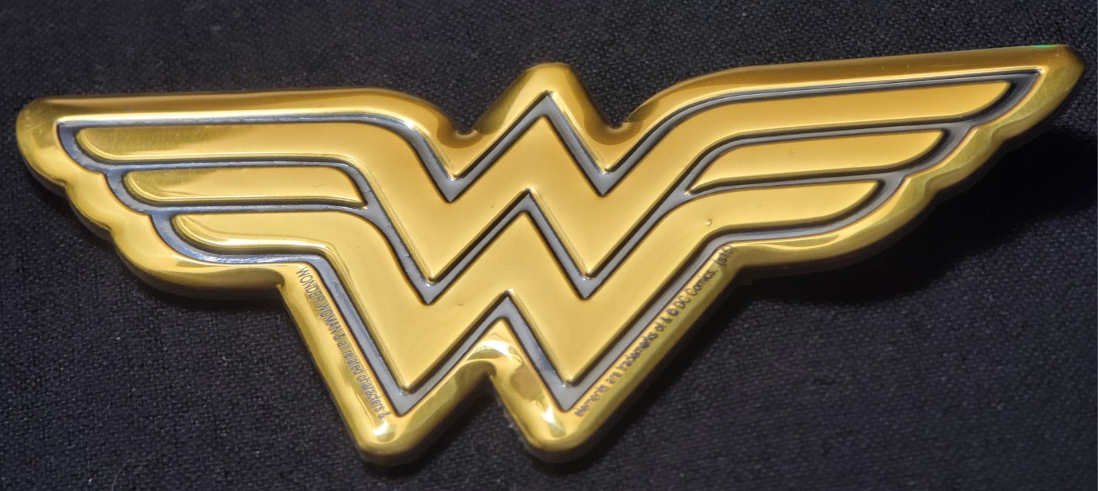 WONDER WOMAN METAL STICKER 3 1/2 X 2" BLACK & GOLD. HAS A GREAT GOLD SHINE TO IT