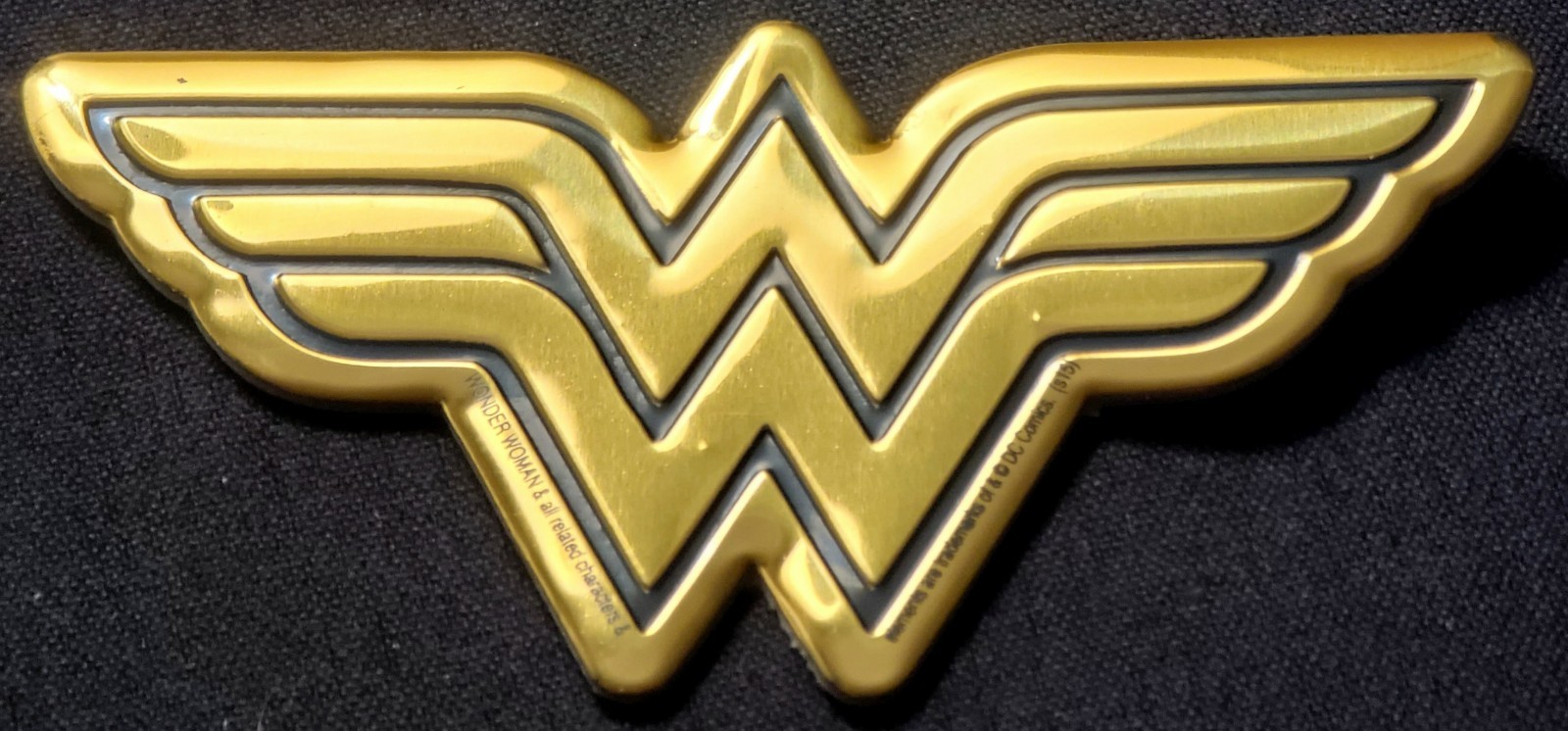 WONDER WOMAN METAL STICKER 3 1/2 X 2" BLACK & GOLD. HAS A GREAT GOLD SHINE TO IT