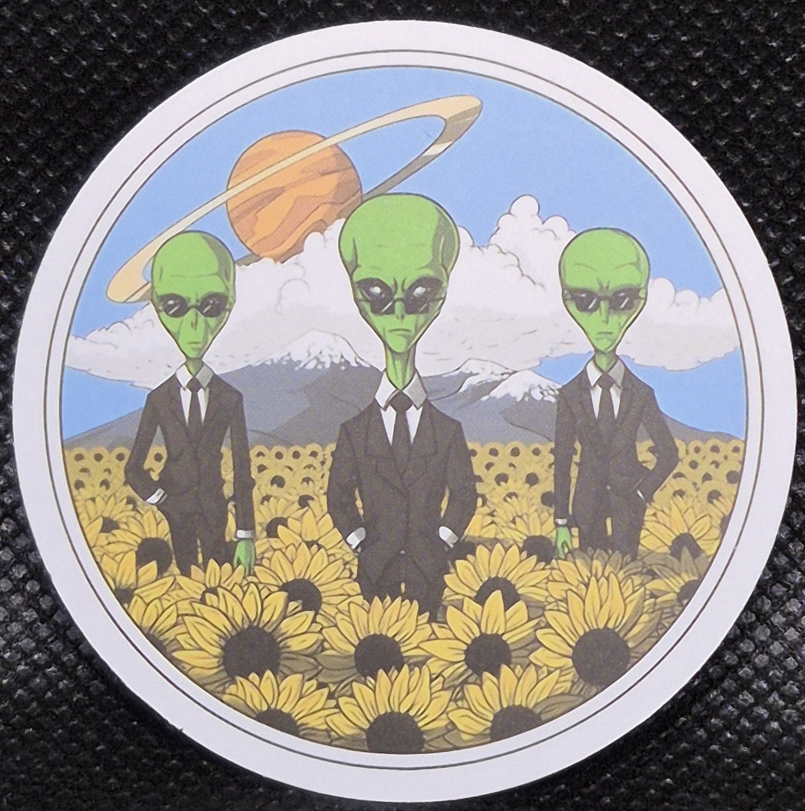 Men In Black Alien UFO UAP Round Decal Sticker. Approximately 2"