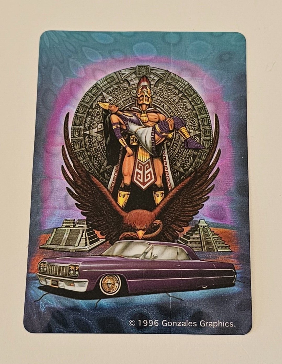 Aztec man holding a woman. Eagle and a purple lowrider sticker by Gonzales Graph