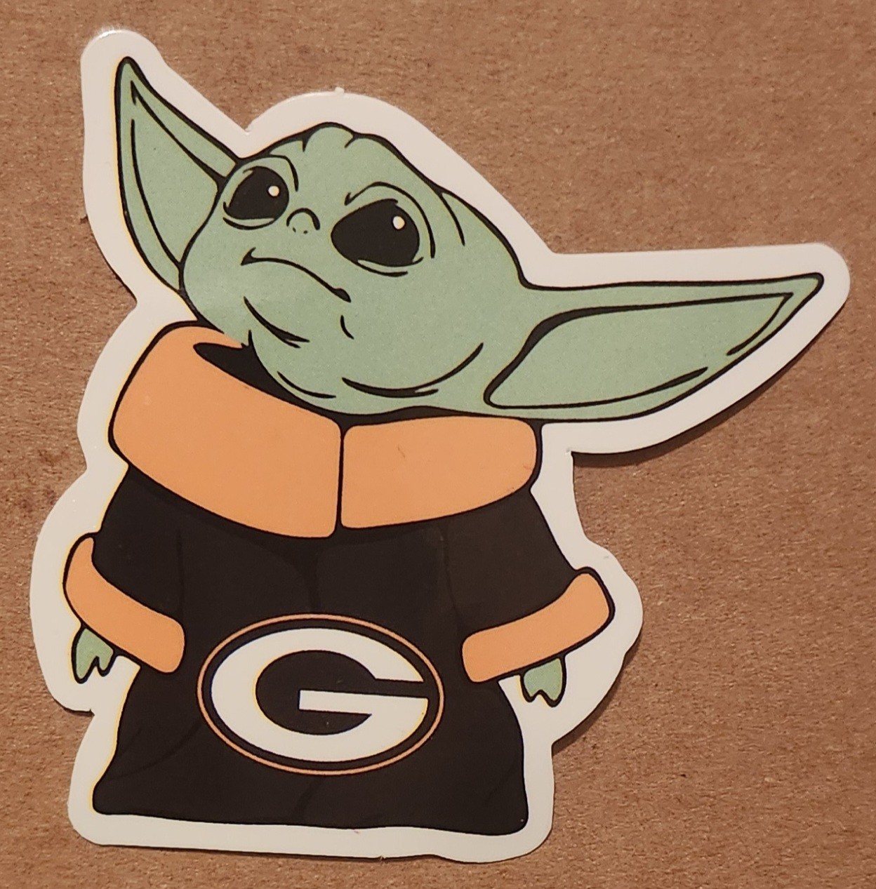 Grogu from The Mandalorian wearing Green Bay Packers logo die-cut decal sticker