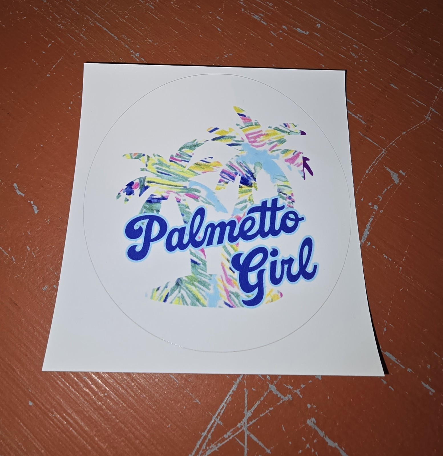 'Palmetto Girl' text and a colorful palm trees background design. 3in Sticker